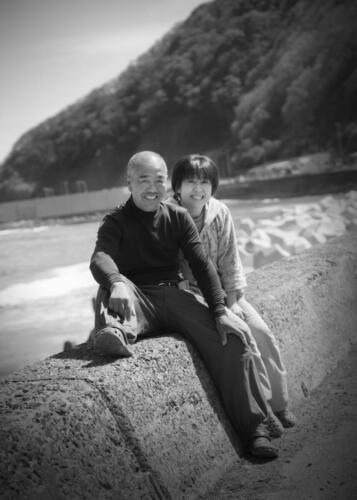 漁師夫妻の記念写真。海岸をバックに。（モノクローム写真）