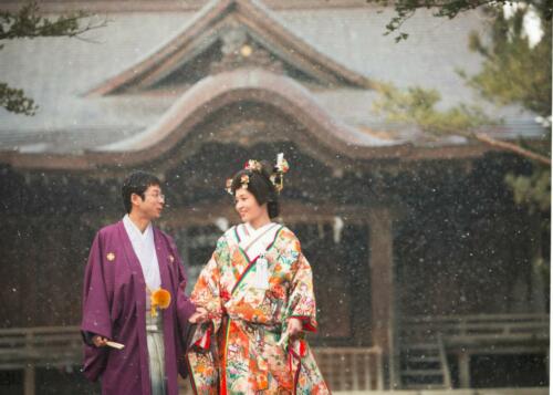 神社正殿前婚礼写真：小雪舞う中で